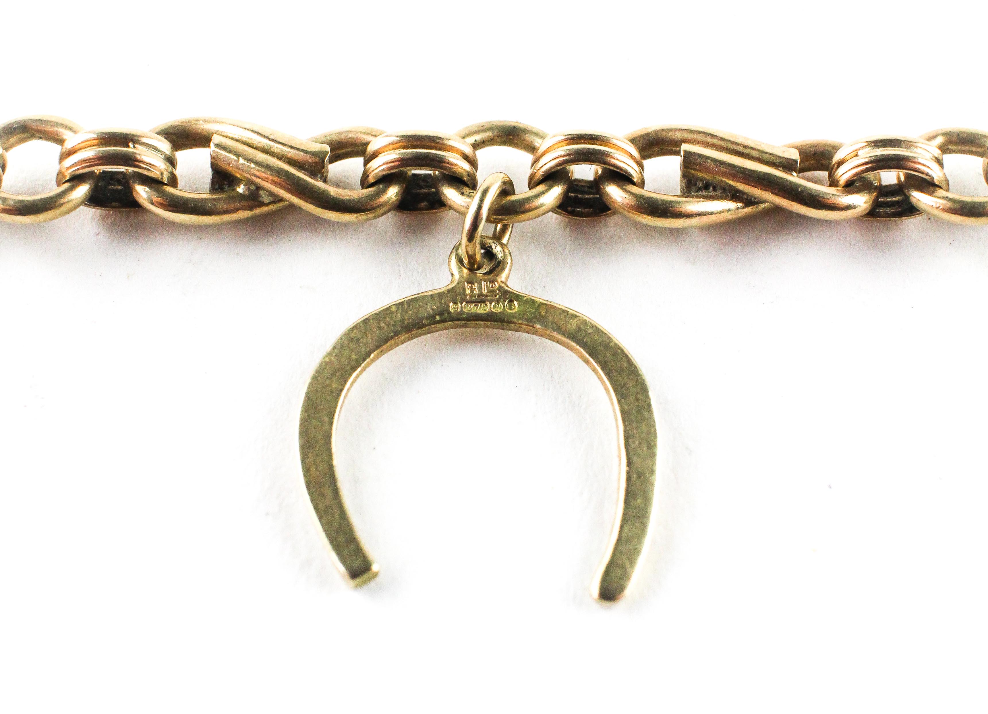 A yellow metal abstract link bracelet fitted with four assorted charms. Hallmarked 9ct gold. - Image 2 of 2