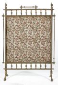A Victorian brass fire screen, with spindle frame, mounted with tapestry style fabric,