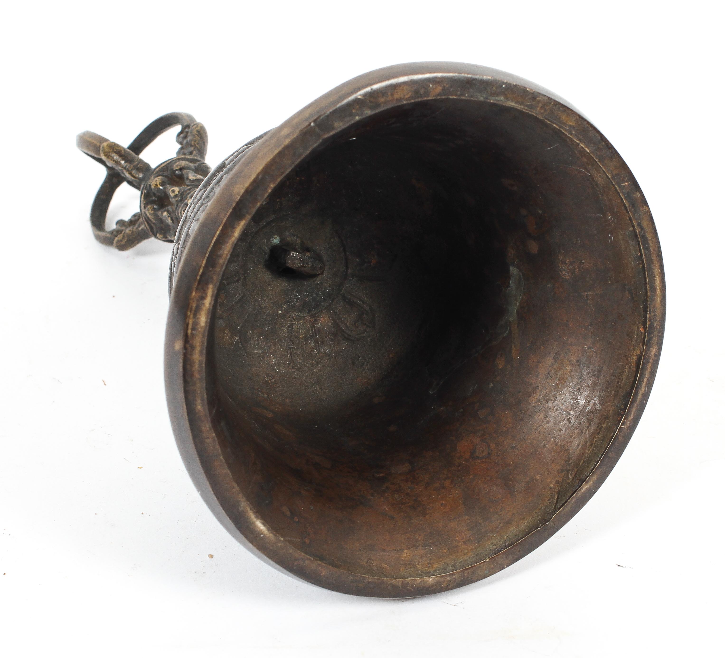 A bronze bell with Asian deity forming handle, the bell cast with swags, - Image 2 of 2