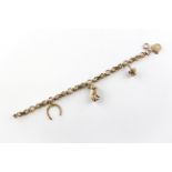 A yellow metal abstract link bracelet fitted with four assorted charms. Hallmarked 9ct gold.