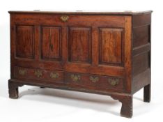 A Georgian oak mule chest, with hinged top, panelled front above two drawers, on ogee feet,