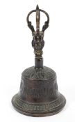 A bronze bell with Asian deity forming handle, the bell cast with swags,