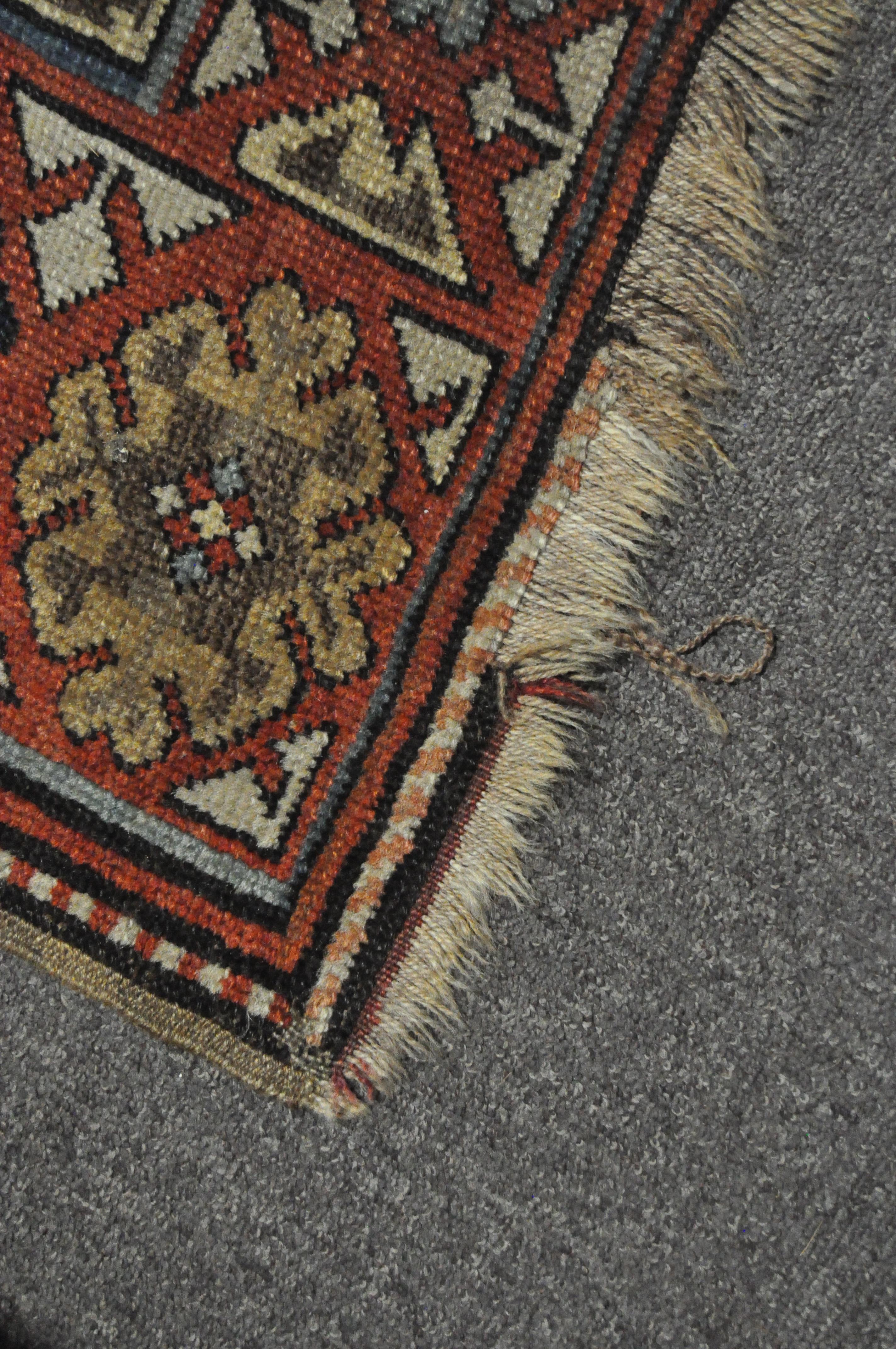 A 20th century Kazak style wool rug, woven with geometric lozenges on a blue ground with red border, - Image 8 of 13