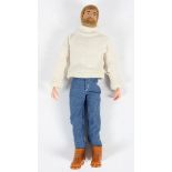 A vintage Action Man with blond hair and beard, in a roll neck sweater,