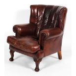 A 20th century leather armchair, in the Georgian style, with wing back, studded,
