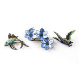 A collection of three silver and enamelled brooches of variable designs.