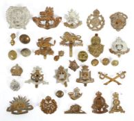 A collection of vintage cap badges and military brass buttons, including WWI examples,