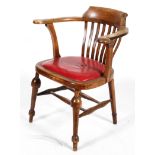An Edwardian elm desk chair, with lathe back and padded seat,