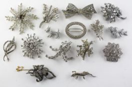 A collection of fifteen costume white metal brooches of variable designs,