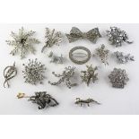 A collection of fifteen costume white metal brooches of variable designs,