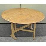 A vintage 1980's golden Ercol Windsor gate leg table of circular form