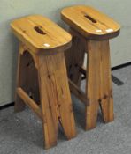 A pair of pine bar stools with curved edges,