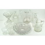 A collection of assorted glassware with moulded decoration, including decanters, pouring jugs,