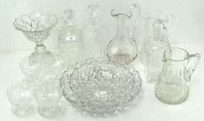 A collection of assorted glassware with moulded decoration, including decanters, pouring jugs,