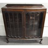 A mahogany bow front display cabinet with two glazed doors enclosing two shelves,