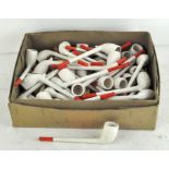 A large number of white plaster smoking pipes with red mouthpieces,