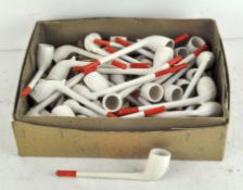 A large number of white plaster smoking pipes with red mouthpieces,