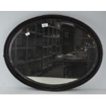 A late 19th/early 20th century oval wall mirror with bevelled edge,