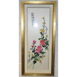 A large Eastern embroidery, featuring flowers with script to the upper left, 100cm x 34cm,