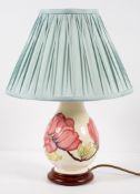 A Moorcroft lamp of bluster form, decorated with pink magnolia on a cream ground, on fitted stand,