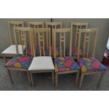 A set of eight vintage wooden dining chairs, six with colour abstract design seats,