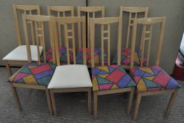 A set of eight vintage wooden dining chairs, six with colour abstract design seats,