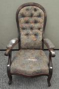 A Victorian button back walnut armchair, covered in a floral fabric,