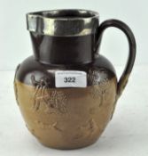 A late Victorian glazed stoneware jug with silver rim,