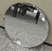 A wall mirror of circular form with bevelled edge,