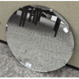 A wall mirror of circular form with bevelled edge,