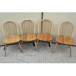 A set of four vintage Ercol hoop and stick back dining chairs raised on turned,