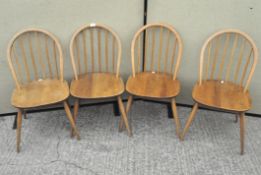 A set of four vintage Ercol hoop and stick back dining chairs raised on turned,