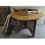 An oak circular dining table, 20th century, on four legs with vertical slatted supports,