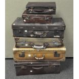 A collection of six assorted suitcases of varying sizes,