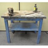 A metal topped wooden work bench, with attached Paramo vice,