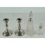 A pair of silver squat candlesticks, 11cm high; together with two silver collared glass bottles