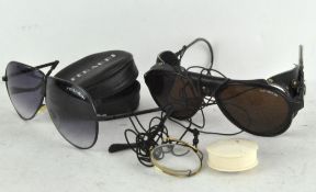 A set of Bolle Irex 100 glasses and a Ferrari glasses with a leather case and a monocle