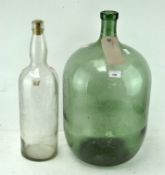 Two large glass bottles, one green, height 54cm, the other clear and stamped 'Bell's Scotch Whisky',