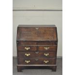 A George III Oak bureau, the drop front opening to reveal fitted interior,