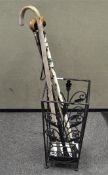 A group of walking sticks with wooden handles, assorted lengths and designs,