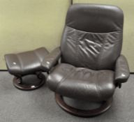 A Stressless armchair and foot stool, upholstered in brown hide,