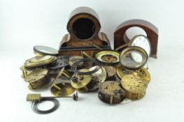 A collection of clock parts, including movements, cases and dials,