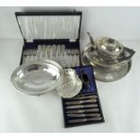 A circular silver plate tray with floral engravings, together with a boxed set of butter knives,