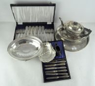 A circular silver plate tray with floral engravings, together with a boxed set of butter knives,