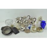A collection of silver plate, including coffee pots with straw handles and a gravy boat,