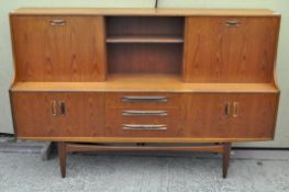 A retro teak sideboard, with drawers and cupboards to the lower tier,