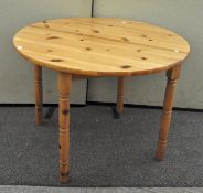 A contemporary round pine kitchen table,