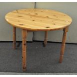 A contemporary round pine kitchen table,