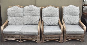A three piece set of conservatory furniture, comprising a sofa and two chairs, with cushions,