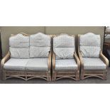 A three piece set of conservatory furniture, comprising a sofa and two chairs, with cushions,